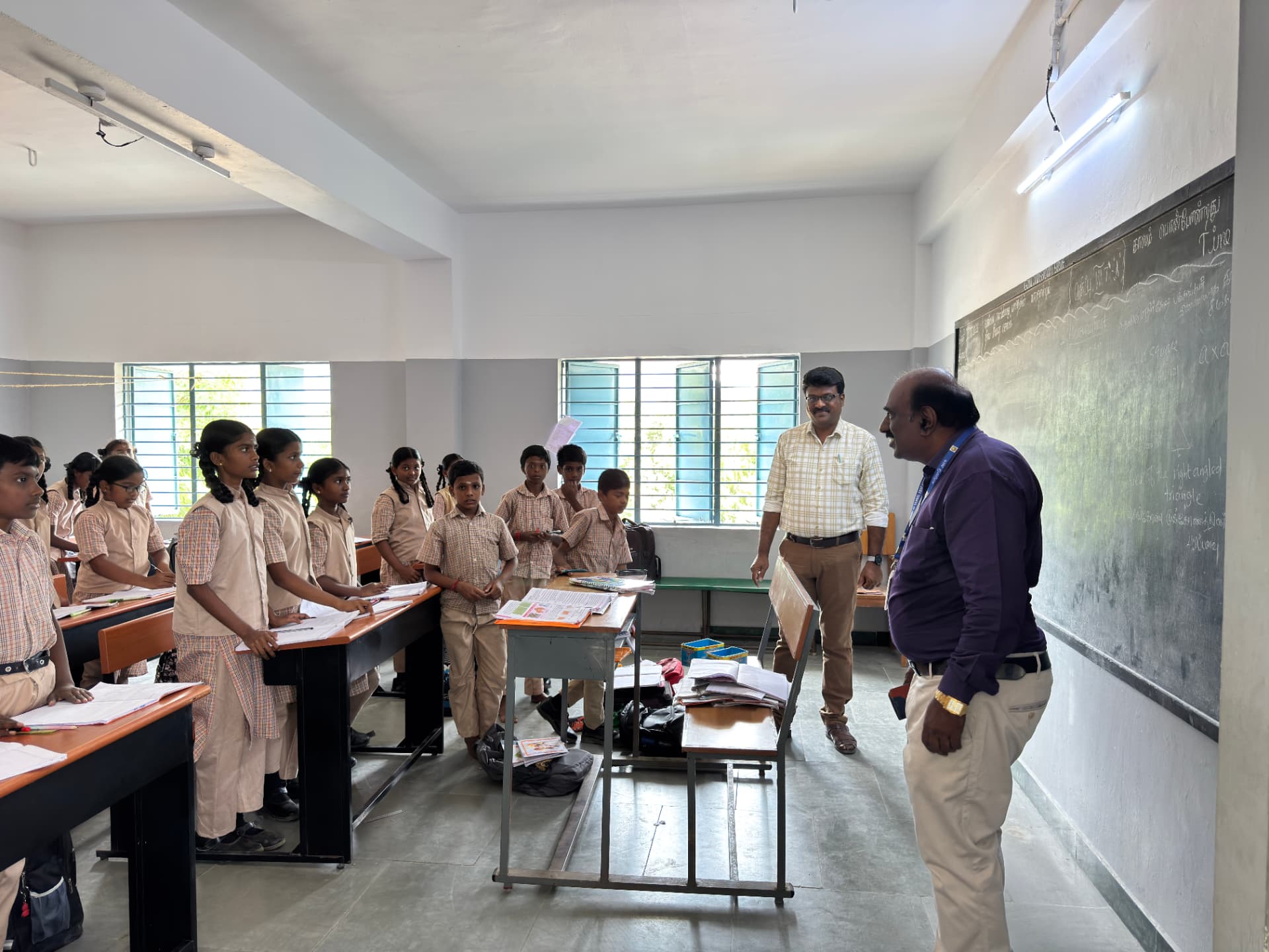 Teachers and students in a classroom at Naickenpalayam before the smart board